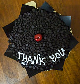 isolated thank you chocolate truffle cake decorated with cherry at coffee table