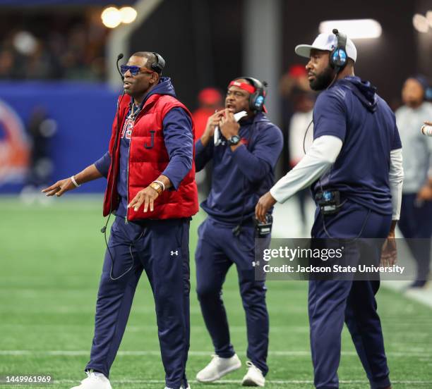 Incoming head coach TC Taylor, right, looks on as outgoing coach Deion Sanders shouts out commands during the Jackson State Tigers and North Carolina...