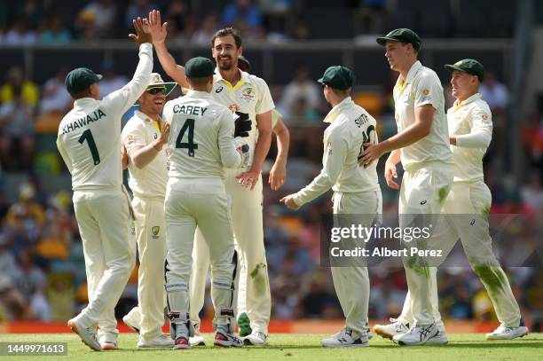 Mitchell Starc of Australia celebrates with team mates after dismissing Keshav Maharaj of South Africa during day two of the First Test match between...