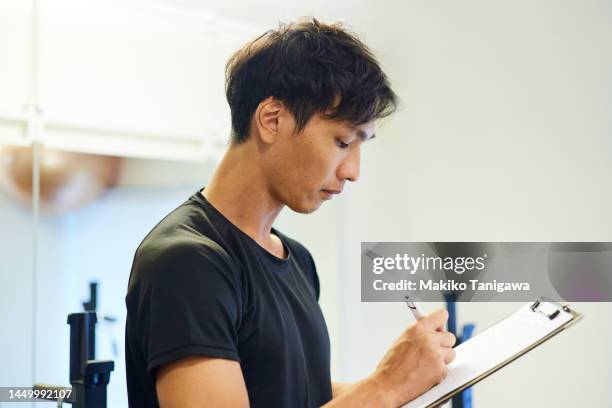 gym instructor filling out paperwork - coach clipboard stock pictures, royalty-free photos & images