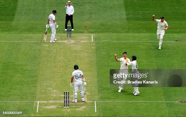 Pat Cummins of Australia celebrates with team mates after taking the wicket of Dean Elgar of South Africa during day two of the First Test match...