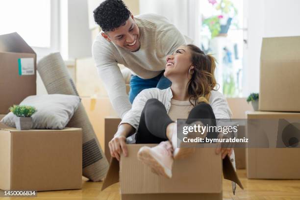 young couple having fun while moving house - homeowner stock pictures, royalty-free photos & images