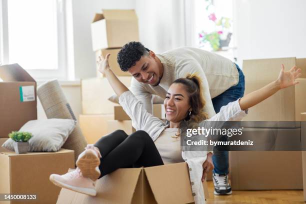 casal está se divertindo com caixas de papelão em casa nova no dia da mudança - mortgage loan - fotografias e filmes do acervo