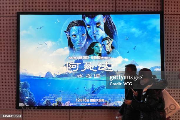 People walk by a poster of film 'Avatar: The Way of Water' at a cinema on December 17, 2022 in Beijing, China.