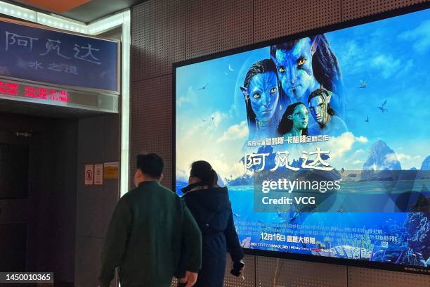 People walk by a poster of film 'Avatar: The Way of Water' at a cinema on December 17, 2022 in Beijing, China.