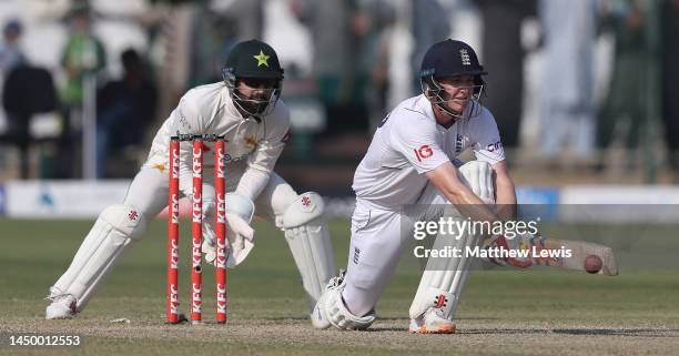 Harry Brook of England plays a reverse sweep, as Mohammad Rizwan of Pakistan watches on during Day Two of the Third Test between Pakistan and England...