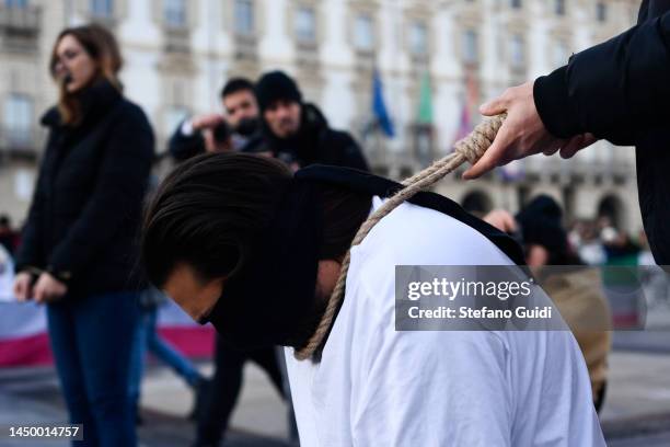 Man holds a man with a noose around his neck during the protest in honor of the lives of Iranian Women on December 17, 2022 in Turin, Italy. In the...