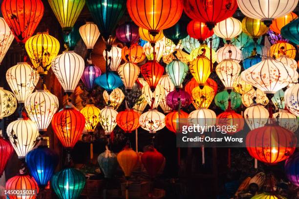 various illuminated paper lanterns hanging at night for celebrating chinese new year - chinese new year foto e immagini stock