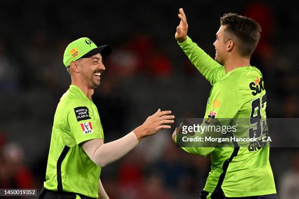 Daniel Sams and Chris Green of the Thunder celebrate a wicket during the Men's Big Bash League match between the Melbourne Renegades and the Sydney...