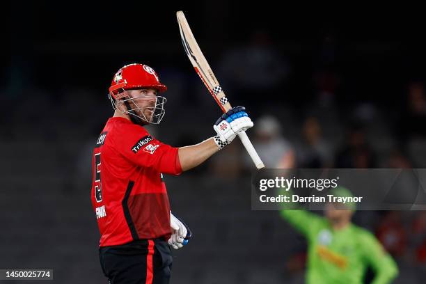 Aaron Finch of the Melbourne Renegades raises his bat after scoring 50 runs during the Men's Big Bash League match between the Melbourne Renegades...