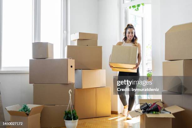 woman carrying boxes into her new place - woman on the move stock pictures, royalty-free photos & images