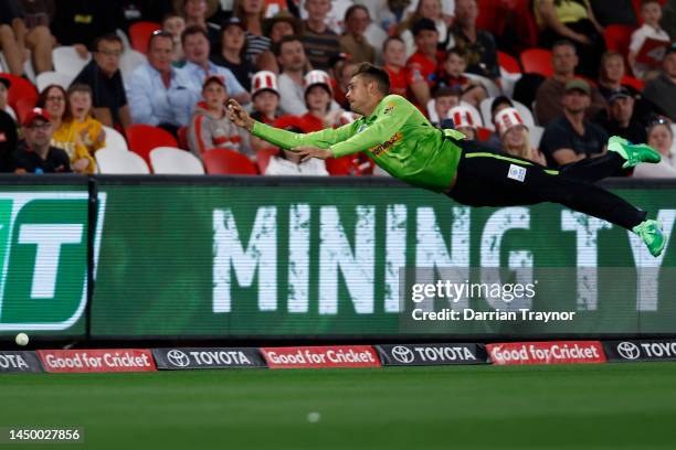 Chris Green of the Sydney Thunder dives in an attempts to mark the ball to ctake a catch in the outfield during the Men's Big Bash League match...