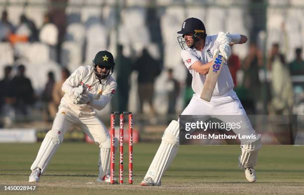 Ollie Robinson of England hits the ball towards the boundary, as Mohammad Rizwan of Pakistan watches on during Day Two of the Third Test between...