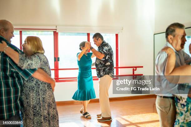 des couples âgés dansent lors d’un cours dans un studio de danse - danse de salon photos et images de collection