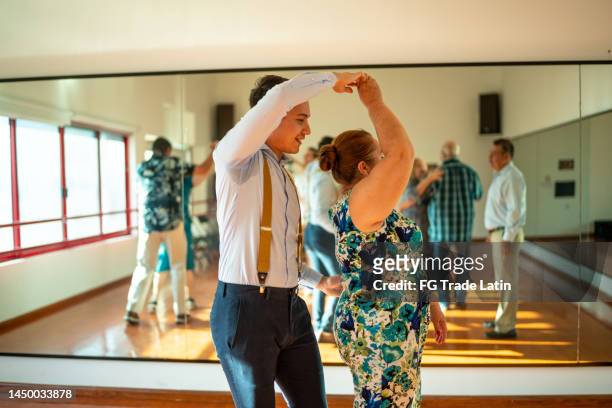 tanzlehrerin unterrichtet ältere frau in einer klasse in einem tanzstudio - swing dancing stock-fotos und bilder