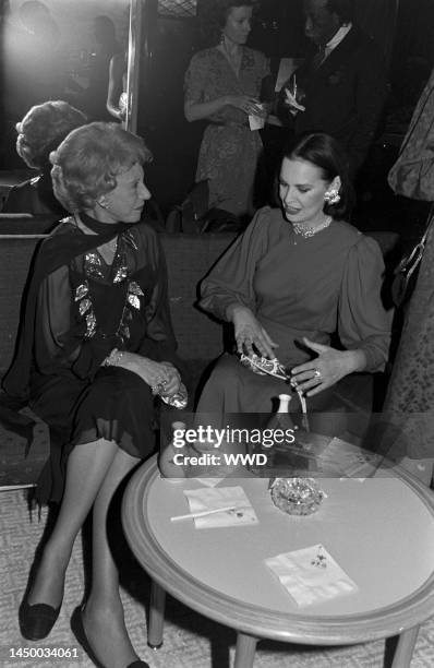 Socialite Gloria Vanderbilt talks to actress Arlene Francis while behind her photographer Gordon Parks talks to socialite Katherine Johnson.
