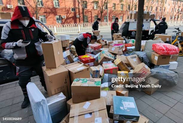 Deliverymen sort express packages on December 17, 2022 in Beijing, China. Couriers from other regions of China have been sent to Beijing to help...