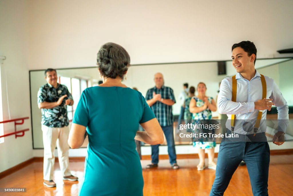 Senior woman dancing with dancing instructor at a dance studio