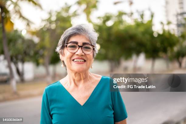 portrait of senior woman outdoors - hispanic woman 60s stock pictures, royalty-free photos & images
