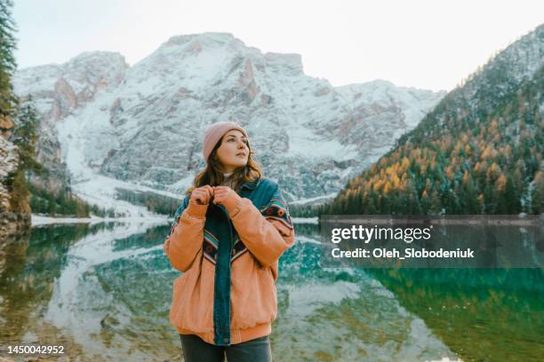 mujer parada cerca del lago di braies en invierno - toma mediana fotografías e imágenes de stock