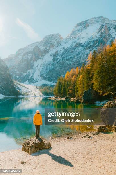 woman  standing on rock on the background of  lago di braies in winter - autumn norway stock pictures, royalty-free photos & images