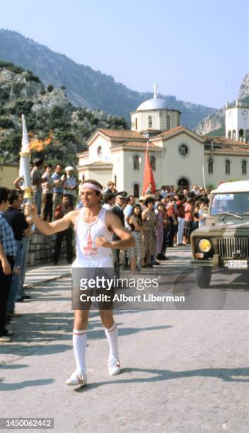 The torchbearer completes his route in a small Greek city, where his torch will light another Olympic cauldron. Greek region. Olympic torch relay....