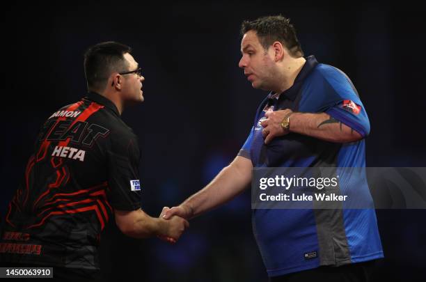 Damon Heta of Australia and Adrian Lewis of England shake hands after their Second Round Match against during Day Four of The Cazoo World Darts...