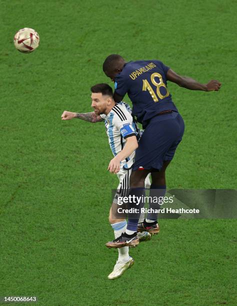 Lionel Messi of Argentina jumps for the ball with Dayot Upamecano of France during the FIFA World Cup Qatar 2022 Final match between Argentina and...