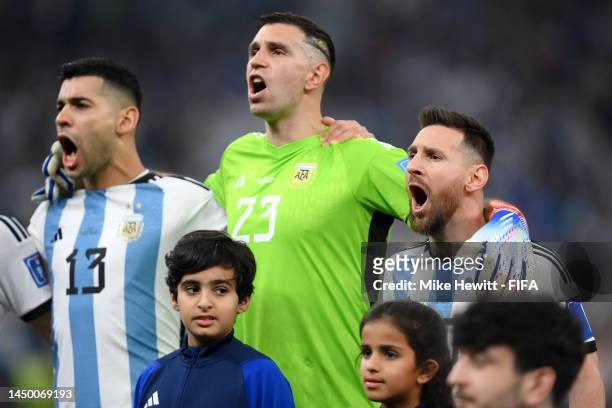 Cristian Romero, Emiliano Martinez and Lionel Messi of Argentina stand for the national anthem prior to the FIFA World Cup Qatar 2022 Final match...