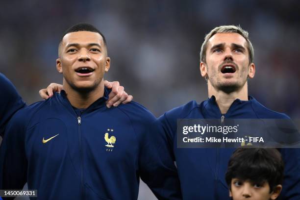 Kylian Mbappe and Antoine Griezmann of France sing their national anthem prior to the FIFA World Cup Qatar 2022 Final match between Argentina and...