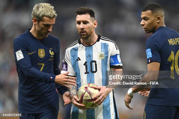Lionel Messi of Argentina interacts with Antoine Griezmann and Kylian Mbappe of France during the FIFA World Cup Qatar 2022 Final match between...