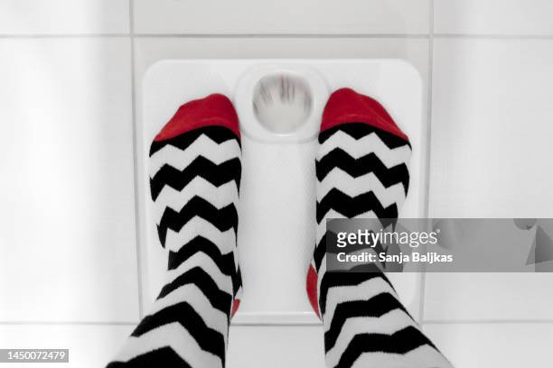 woman feet weighing scale - kilogramm stock-fotos und bilder