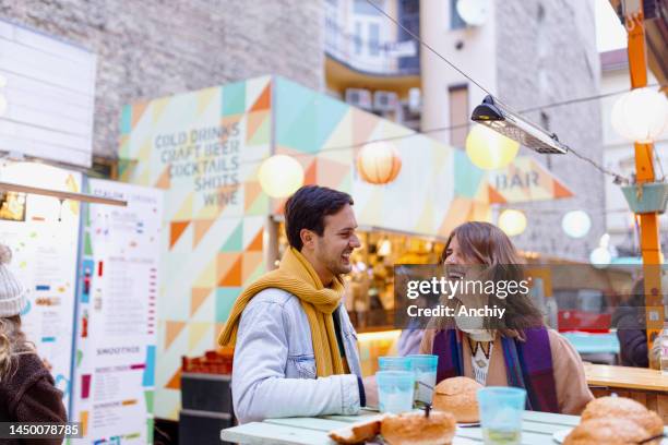 happy couple laughing during dinner near food truck - traditionally hungarian stock pictures, royalty-free photos & images