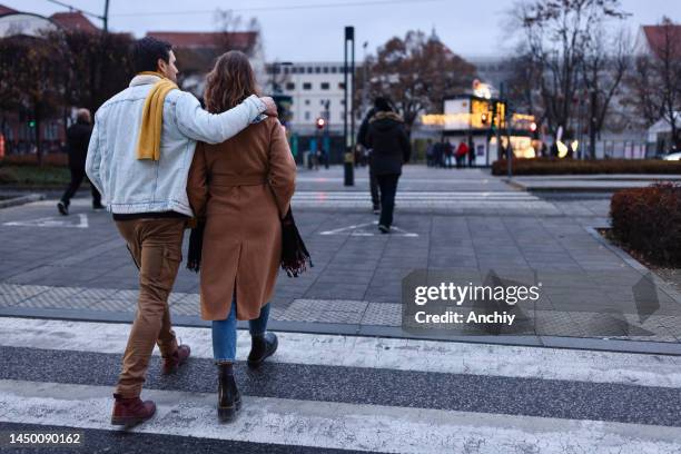 young couple on a date enjoying city life - couple crossing street stock pictures, royalty-free photos & images