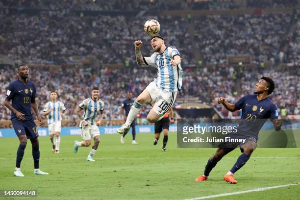 Lionel Messi of Argentina jumps for the ball with Kingsley Coman of France during the FIFA World Cup Qatar 2022 Final match between Argentina and...