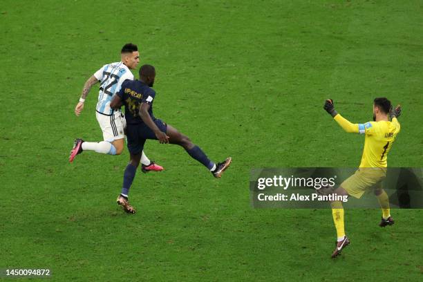 Lautaro Martinez of Argentina shoots the ball against Dayot Upamecano and Hugo Lloris of France during the FIFA World Cup Qatar 2022 Final match...