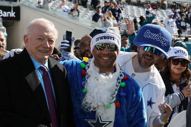 Dallas Cowboys owner Jerry Jones takes a photo with fans prior to a game against the Jacksonville Jaguars at TIAA Bank Field on December 18, 2022 in...