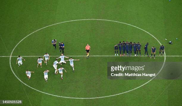 Argentina players celebrate the fourth and winning penalty by Gonzalo Montiel in the penalty shootout as France players react during the FIFA World...