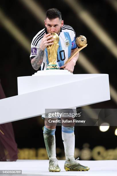 Lionel Messi of Argentina kisses the FIFA World Cup Qatar 2022 Winner's Trophy while holding the adidas Golden Boot award after the FIFA World Cup...