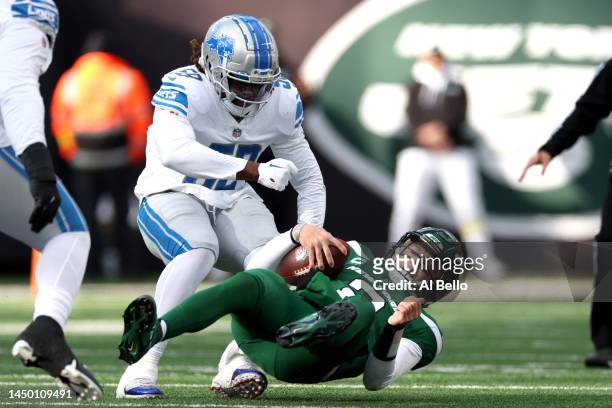 Zach Wilson of the New York Jets is sacked by James Houston of the Detroit Lions during the first quarter at MetLife Stadium on December 18, 2022 in...