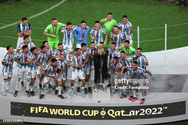 Lionel Messi of Argentina celebrates with team mates as he lifts the FIFA World Cup following the penalty shoot out victory during the FIFA World Cup...