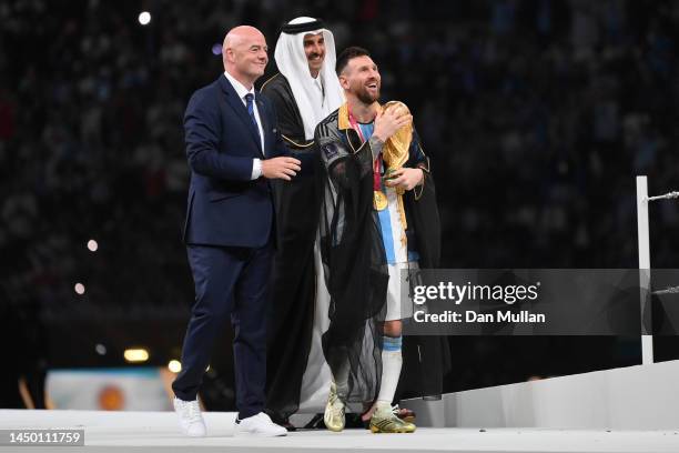 Lionel Messi of Argentina holds the FIFA World Cup Qatar 2022 Winner's Trophy as he interacts with Gianni Infantino, President of FIFA, and Sheikh...