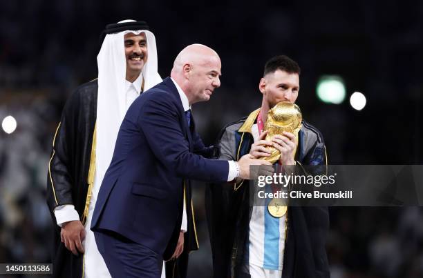 Gianni Infantino, President of FIFA, hands the The FIFA World Cup Qatar 2022 Winner's Trophy to Lionel Messi of Argentina in the trophy presentation...