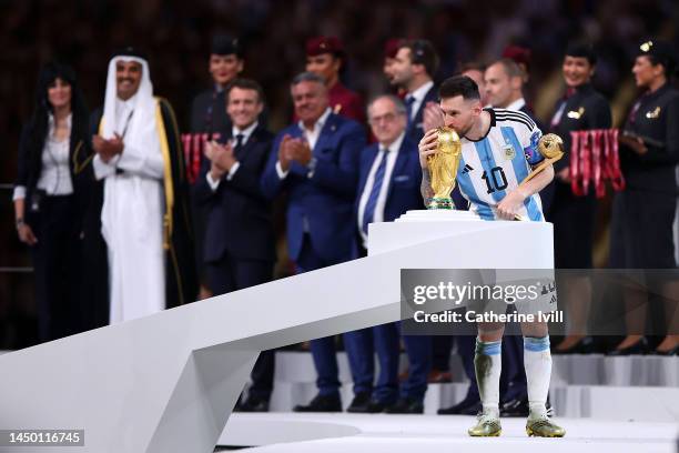 Lionel Messi of Argentina kisses the FIFA World Cup Qatar 2022 Winners' Trophy while holding the adidas Golden Boot award after the FIFA World Cup...