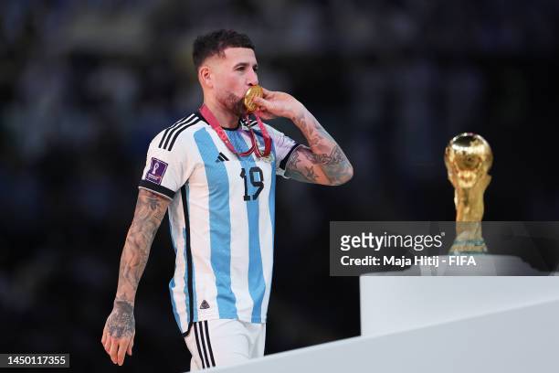 Nicolas Otamendi of Argentina walks past The FIFA World Cup Qatar 2022 Winner's Trophy in the trophy presentation after the team's victory during the...