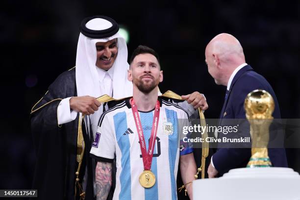 Lionel Messi of Argentina is presented with a traditional robe by Sheikh Tamim bin Hamad Al Thani, Emir of Qatar, while Gianni Infantino, President...