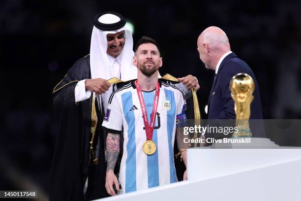 Lionel Messi of Argentina is presented with a traditional robe by Sheikh Tamim bin Hamad Al Thani, Emir of Qatar, while Gianni Infantino, President...