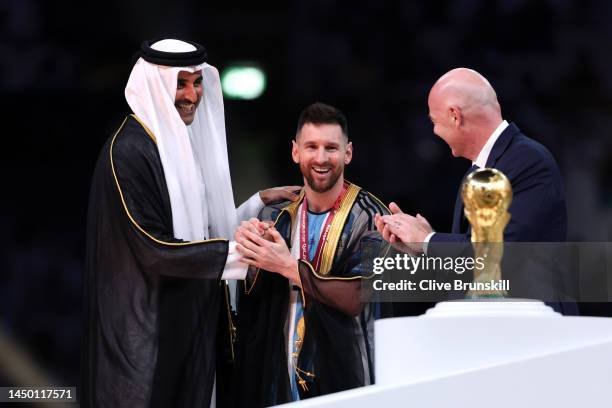 Lionel Messi of Argentina is presented with a traditional robe by Sheikh Tamim bin Hamad Al Thani, Emir of Qatar, while Gianni Infantino, President...