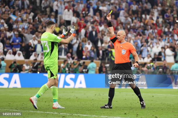 Emiliano Martinez of Argentina is shown a yellow card by referee Szymon Marciniak in the penalty shootout during the FIFA World Cup Qatar 2022 Final...