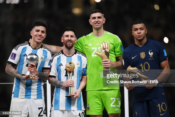 Enzo Fernandez of Argentina poses for a photo with the FIFA Young Player award, Lionel Messi of Argentina poses for a photo with the adidas Golden...